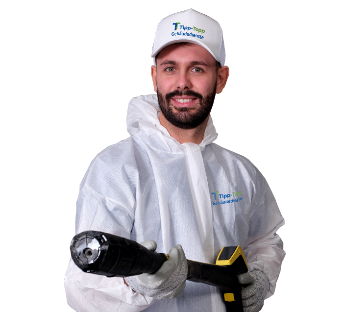 Ein Mitarbeiter für Graffitientfernung in weisser Arbeitskleidung mit Hochdruckreiniger