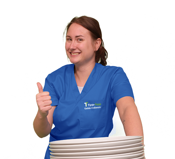 Eine Mitarbeiterin beim Spüldienst in blauer Arbeitskleidung mit einem Stapel Teller und Daumen hoch
